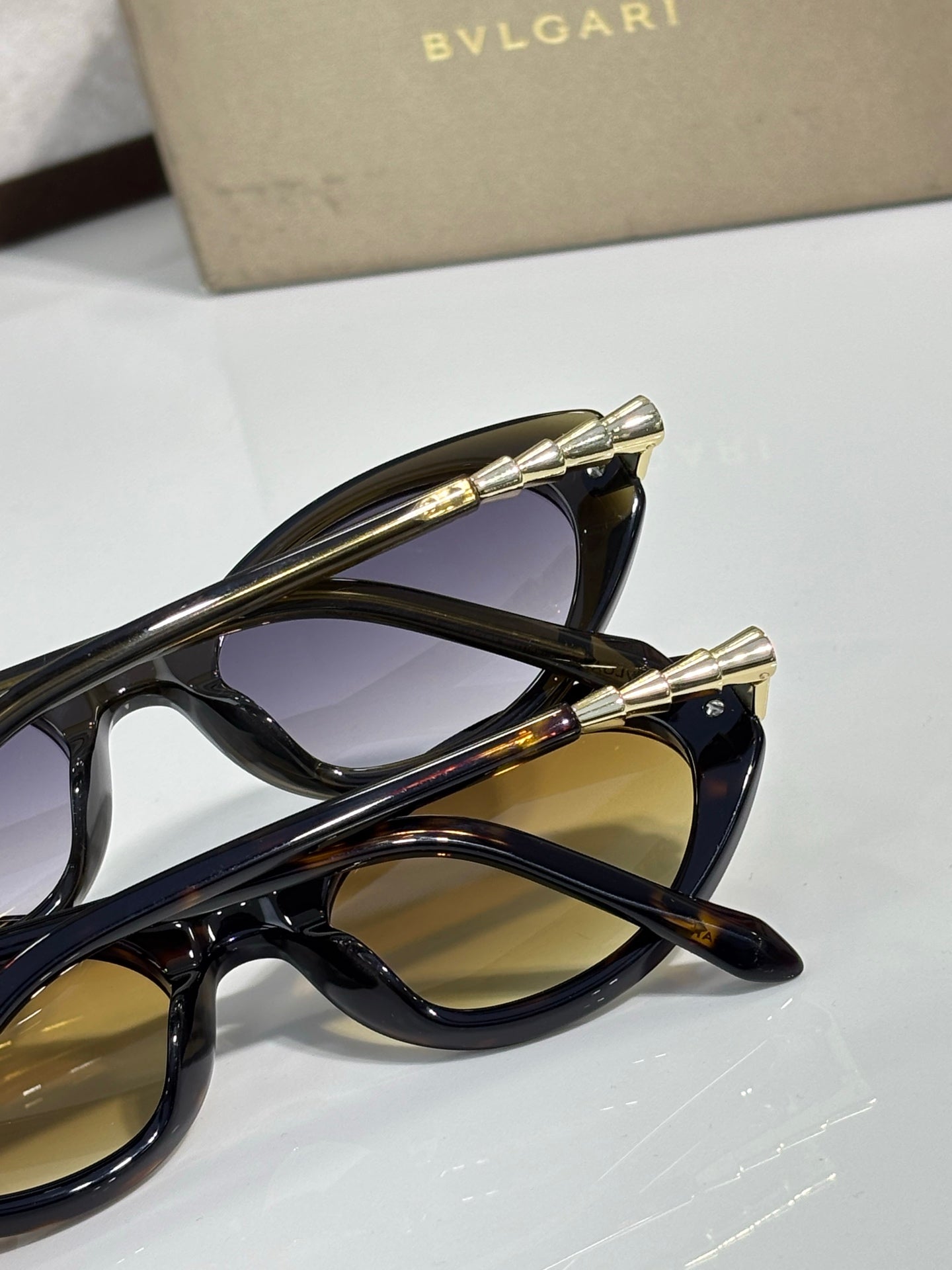 Black sunglasses close-up with gold-tone temple tips and tinted lenses