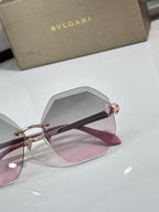 Sunglasses close-up with pink-tinted lenses and rose-gold frame, gold hinge detail.