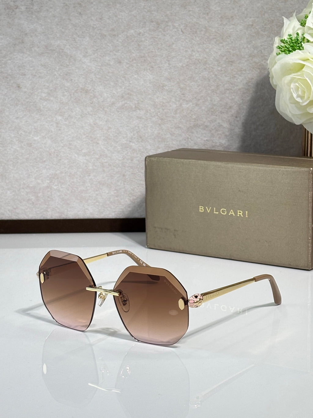 Sunglasses with brown lenses and rose-gold frame, gold-tone bridge and temples.