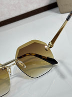 Sunglasses close-up with amber lenses and gold-tone frame, curved corner design.