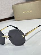 Sunglasses close-up: dark lenses with black frame and gold-tone details on bridge.