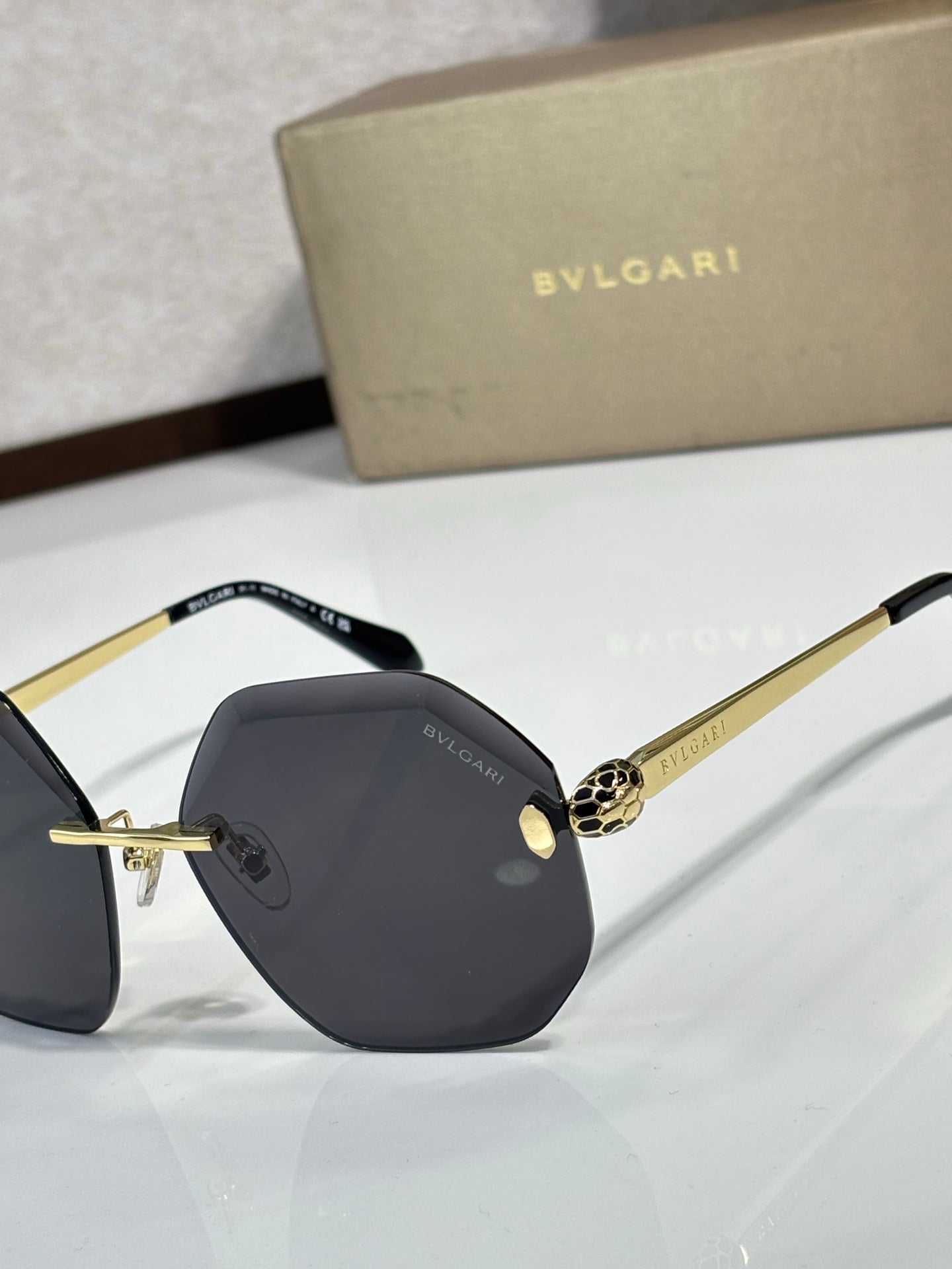 Sunglasses close-up: dark lenses with black frame and gold-tone details on bridge.