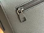 Men's Louis Vuitton leather shoulder bag closeup with zipper pull and hanging leather tag