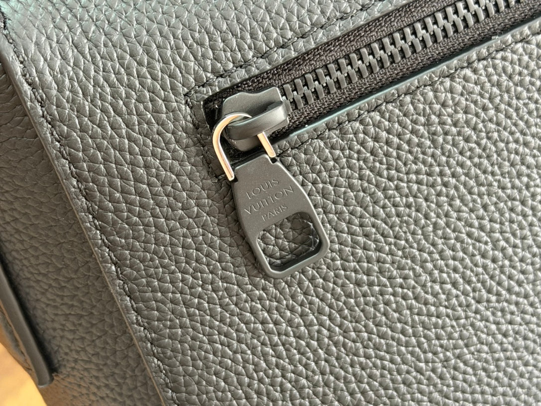 Men's Louis Vuitton leather shoulder bag closeup with zipper pull and hanging leather tag