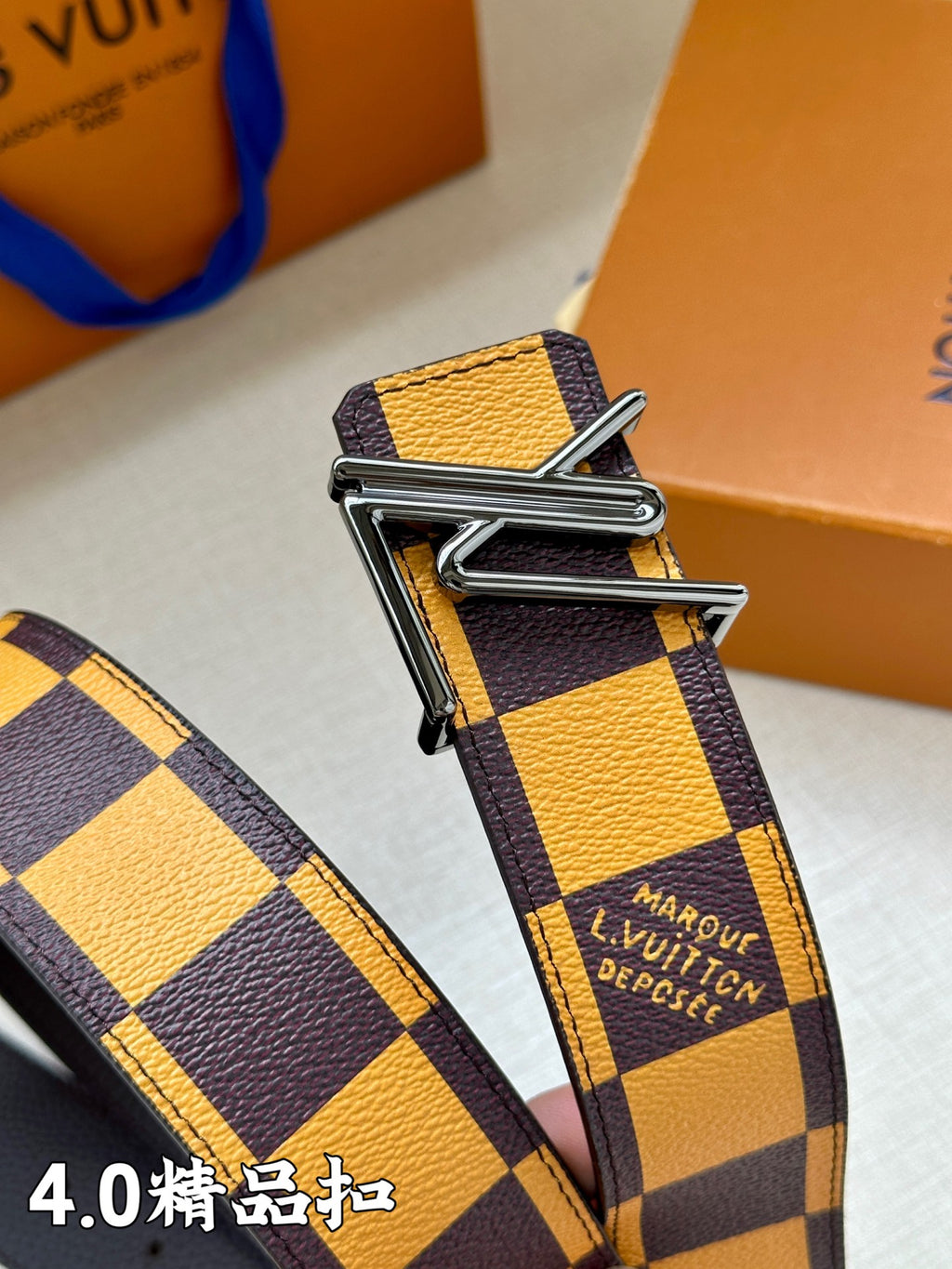 Louis Vuitton belt buckle detail with dark-and-yellow check strap and printed text