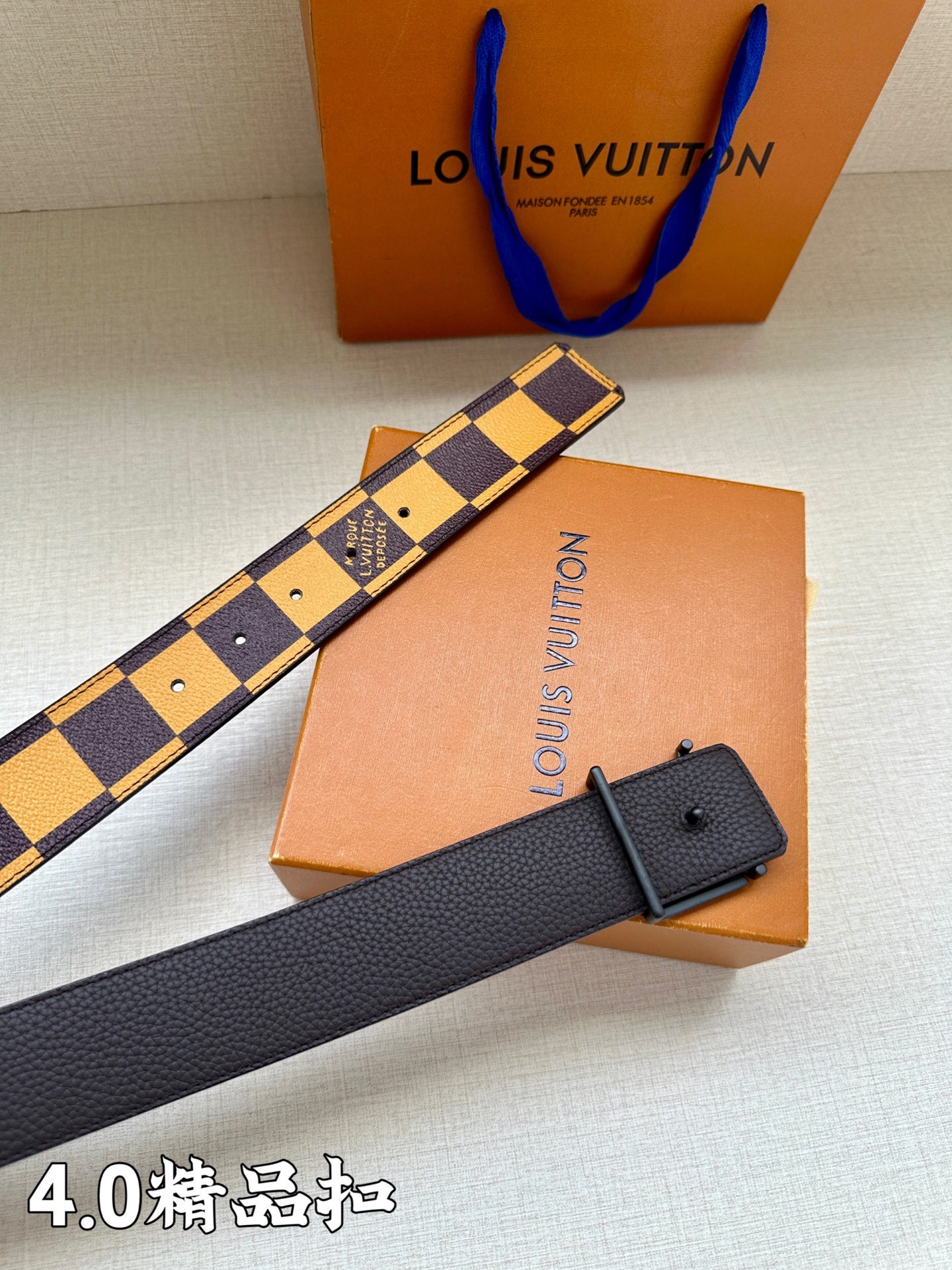 Checkered leather belt with metal buckle, plus matching black strap piece