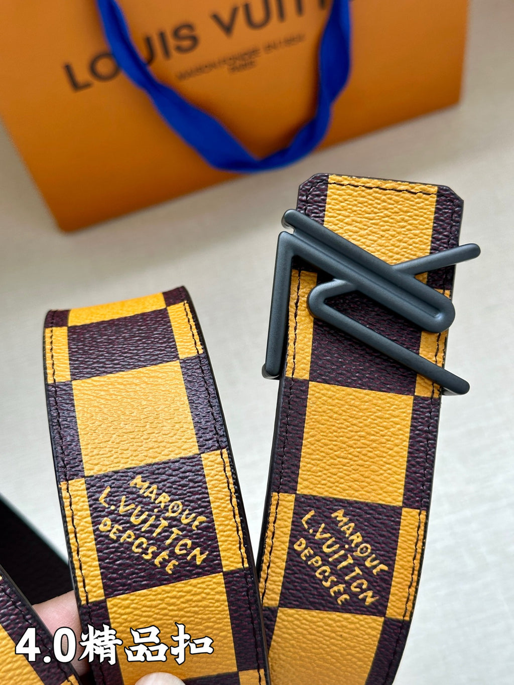 Checkered belt strap with LV-printed end and metal buckle, two angles
