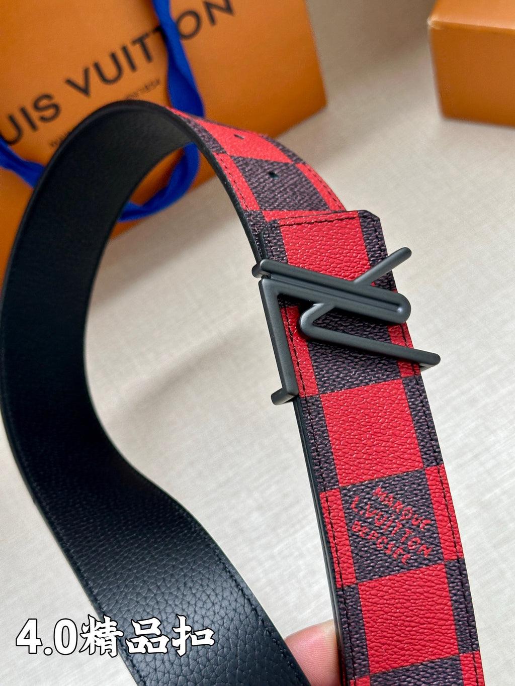 Check-pattern belt with black buckle and textured strap end