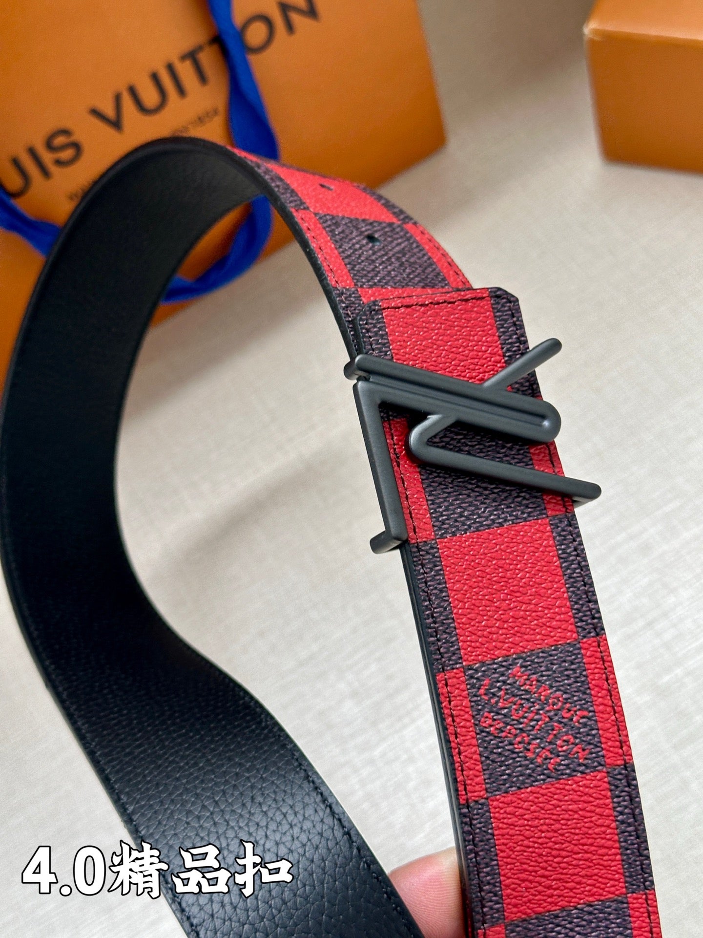 Check-pattern belt with black buckle and textured strap end