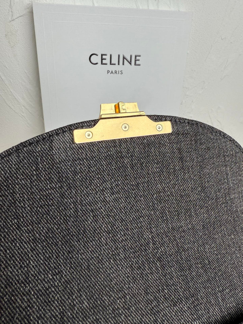 Gray Celine handbag back view with gold bar clasp hardware and snaps.
