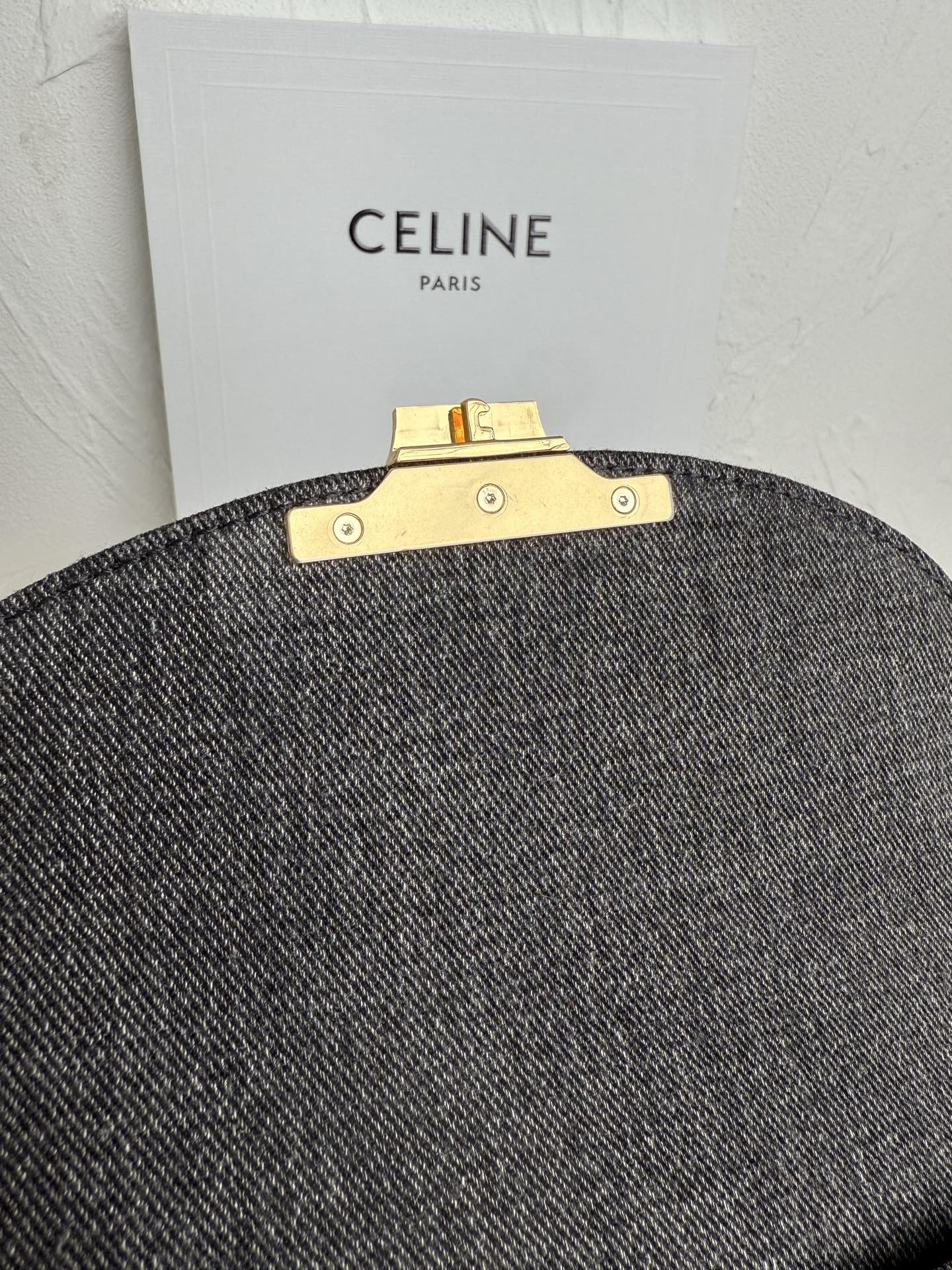 Gray Celine handbag back view with gold bar clasp hardware and snaps.