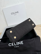 Gray Celine handbag back with four white studs and curved profile.