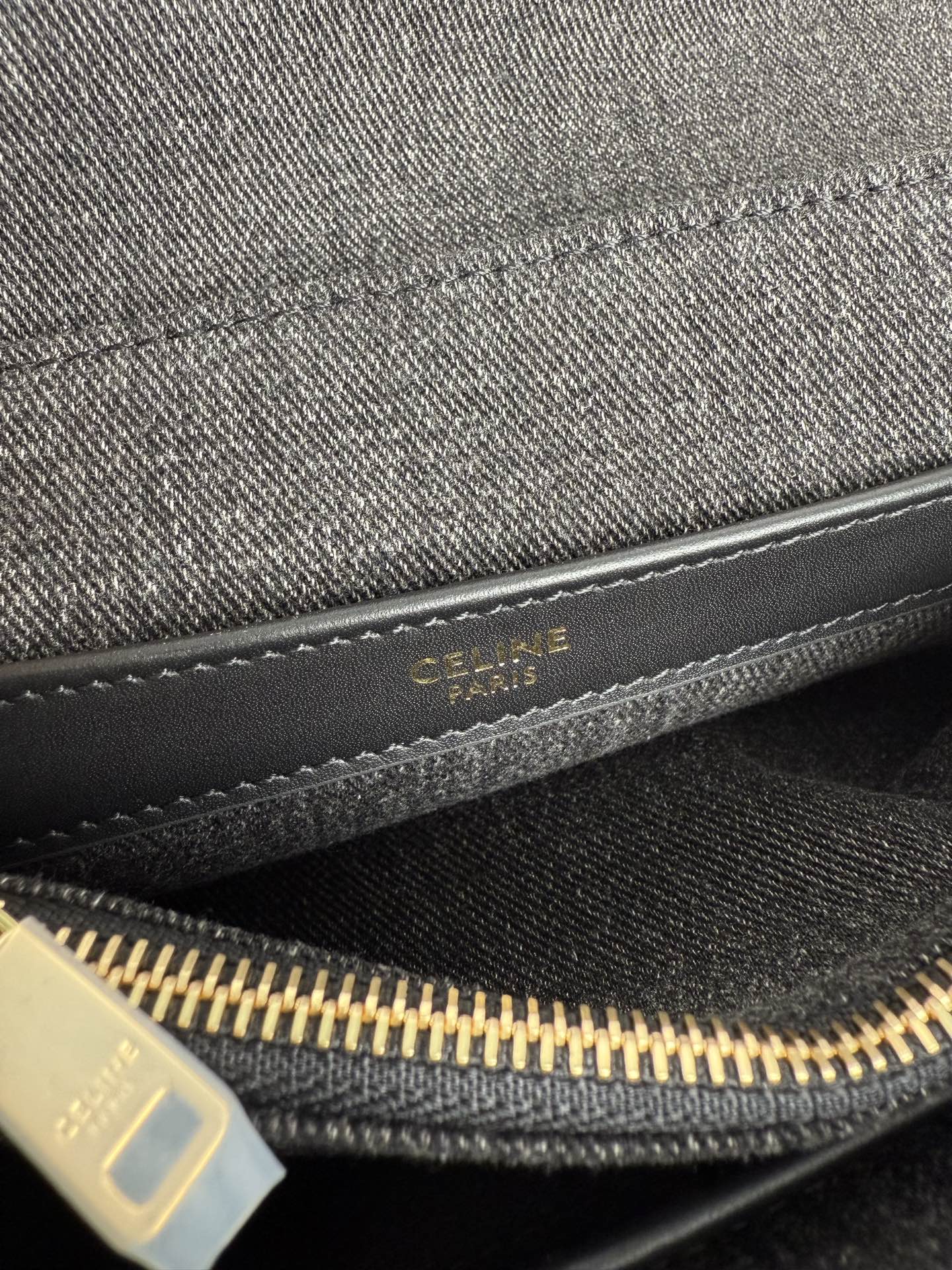 Gray Celine handbag interior zipper with gold track and logo patch.