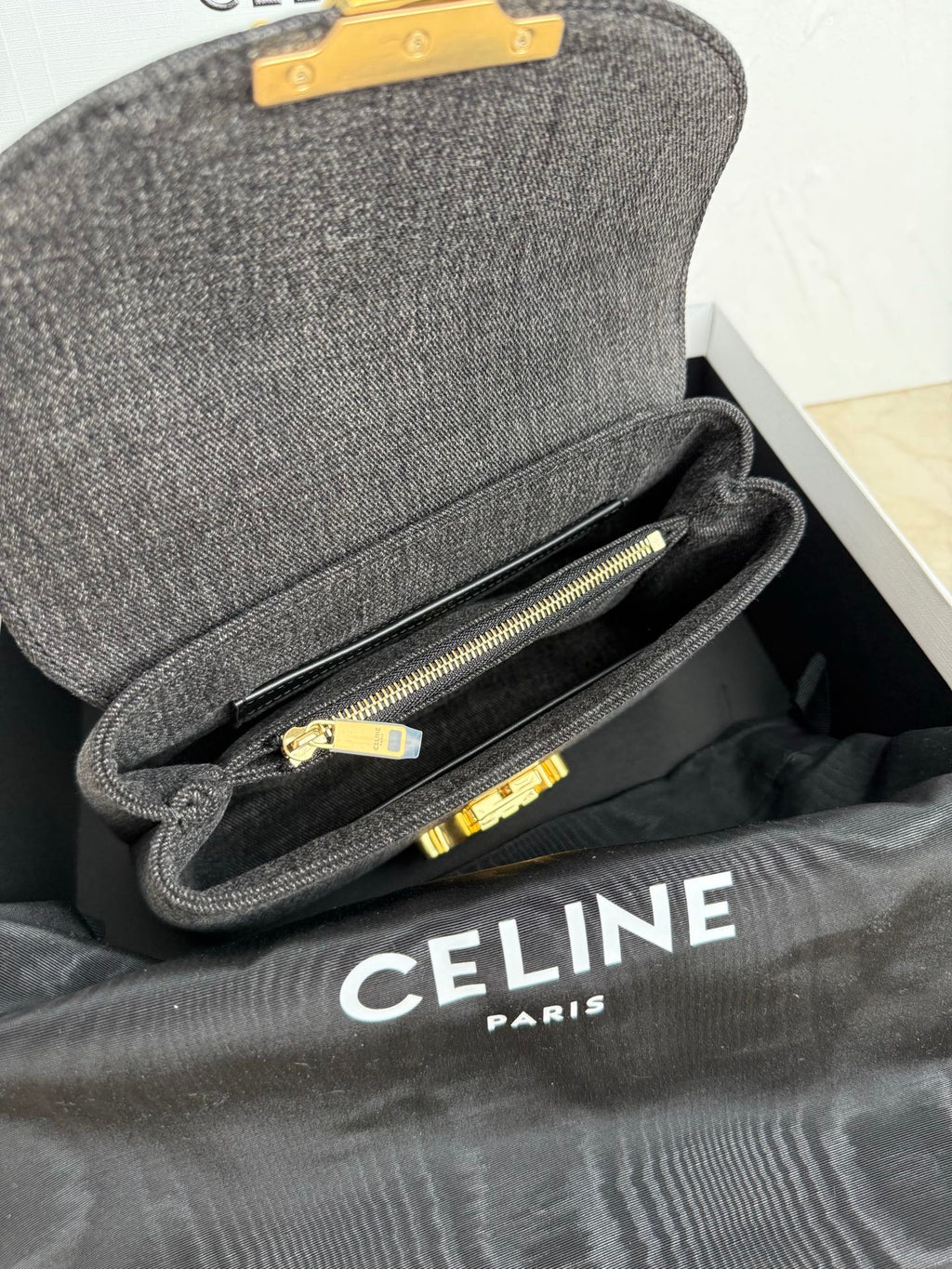 Gray Celine handbag open with interior zipper pocket and gold hardware.