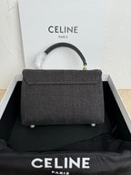 Gray Celine handbag with top handle and flap, gold clasp, short feet detail.