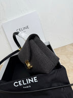Gray Celine handbag with side view, white strap wrap and gold trim hardware.