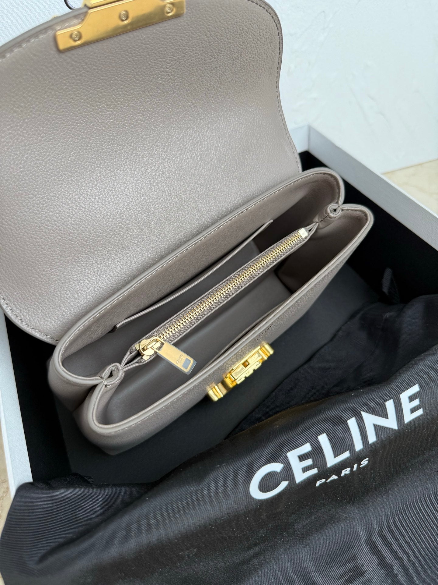 Celine taupe mini bag open view with internal compartment and gold zipper pull