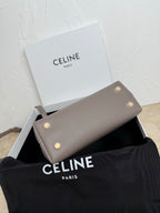 Celine taupe clutch-style bag with snap buttons on front and gold hardware