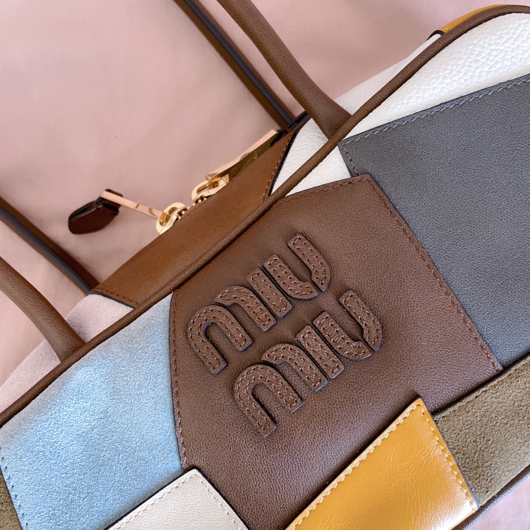 MiuMiu patchwork leather handbag close-up of embossed logo on brown panel