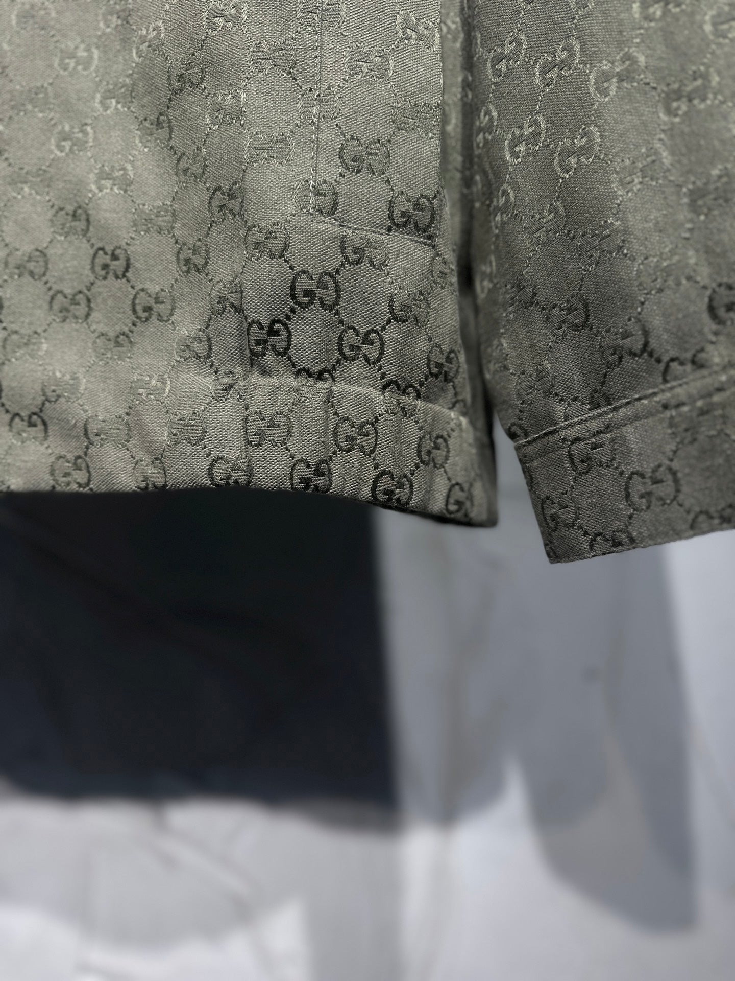 Gucci-pattern jacket hem and cuff detail with dark trim