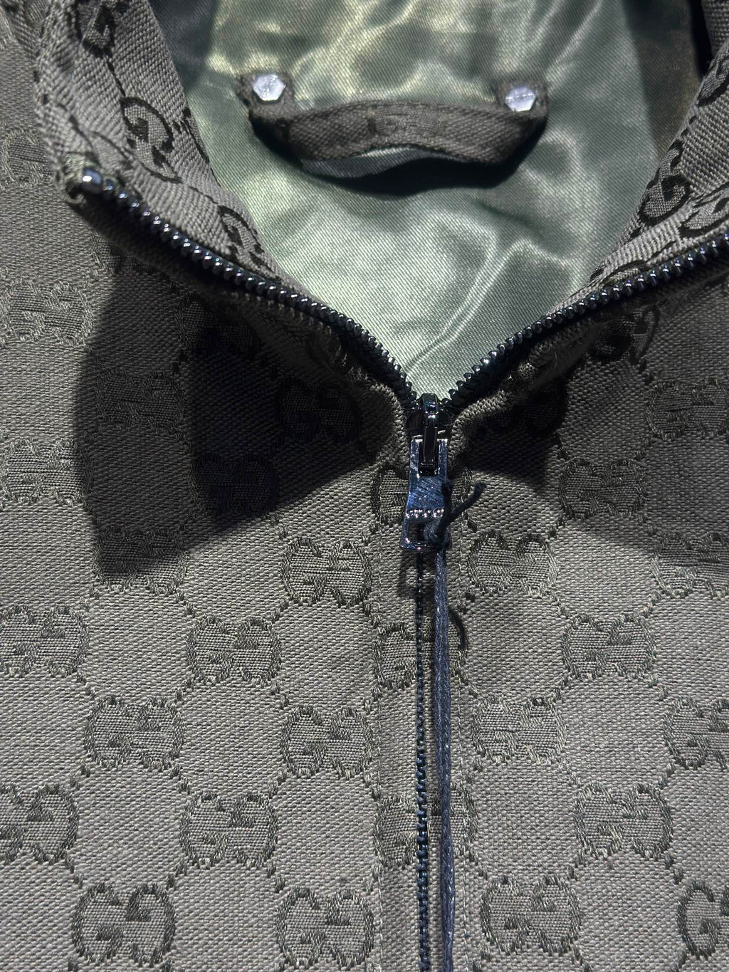 Gucci-pattern zip jacket front with exposed zipper and dark trim