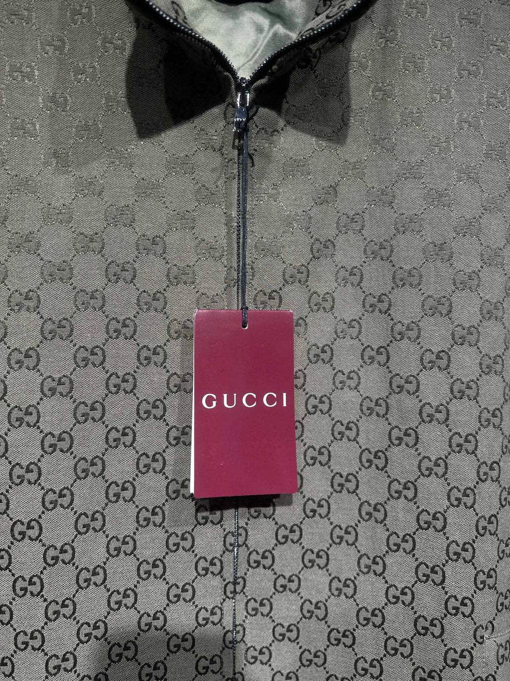 Gucci-pattern zip jacket with hanging brand tag