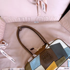 MiuMiu patchwork leather handbag close-up with top handle strap and embossed logo patch