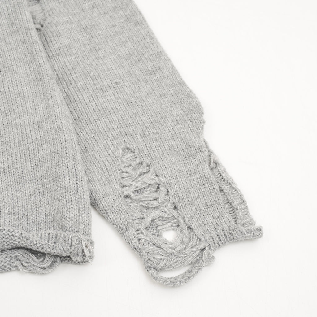 Heather gray sweater sleeves with frayed distressed stitching at ribbed cuff