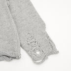 Heather gray sweater sleeves with frayed distressed stitching at ribbed cuff