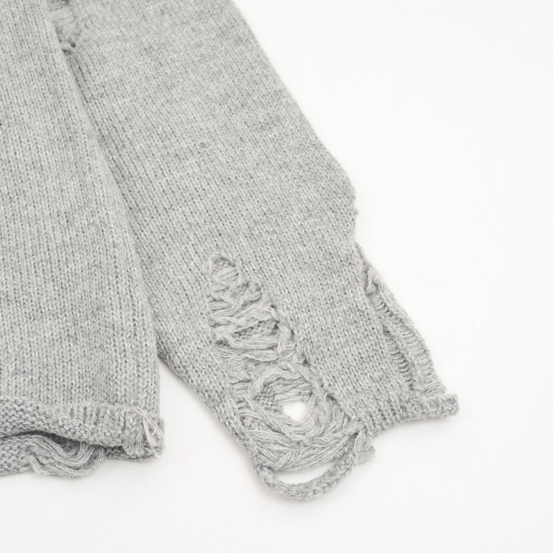 Heather gray sweater sleeves with frayed distressed stitching at ribbed cuff