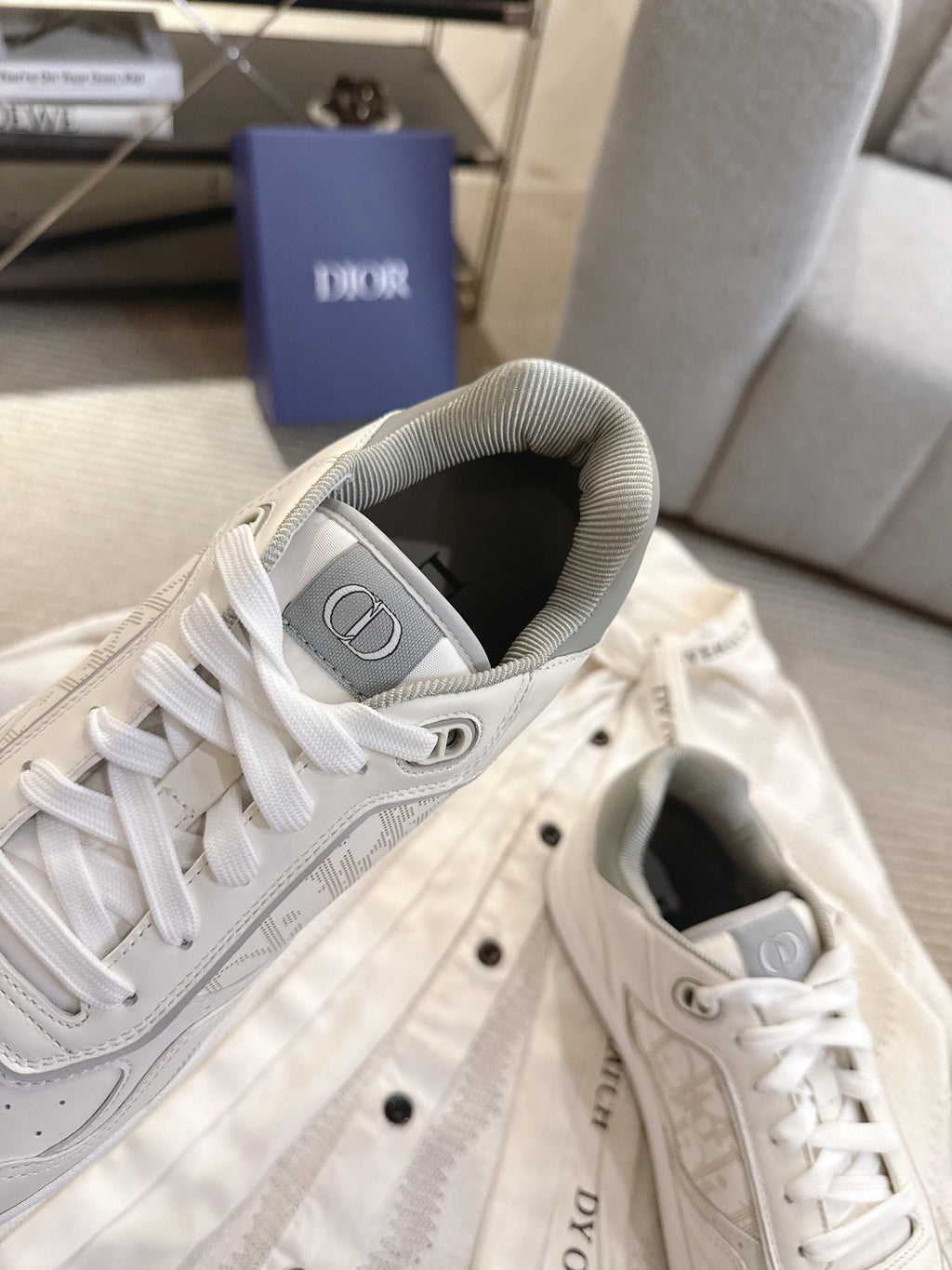 Dior unisex sneakers showing heel and tongue, white lace-up leather with logo patch