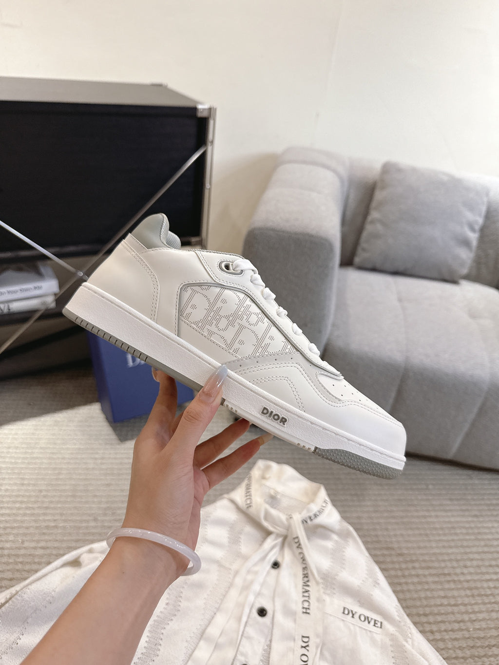 Dior unisex sneakers close-up, white leather lace-up with Dior logo on side