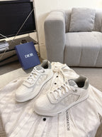 Dior unisex low-top sneakers pair, white leather with lace-up and side emblem print