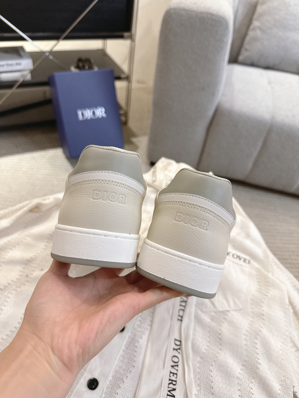 Pair of off-white low-top sneakers showing heel backs with gray side detailing