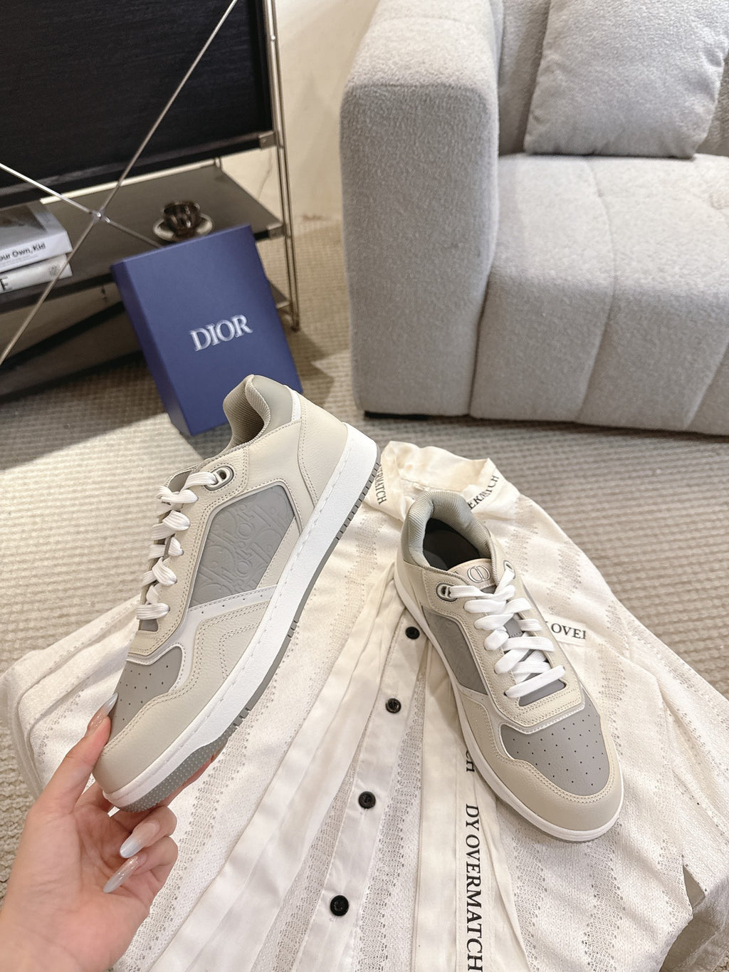 Low-top sneaker in off-white with gray side panel and white lace-up closure