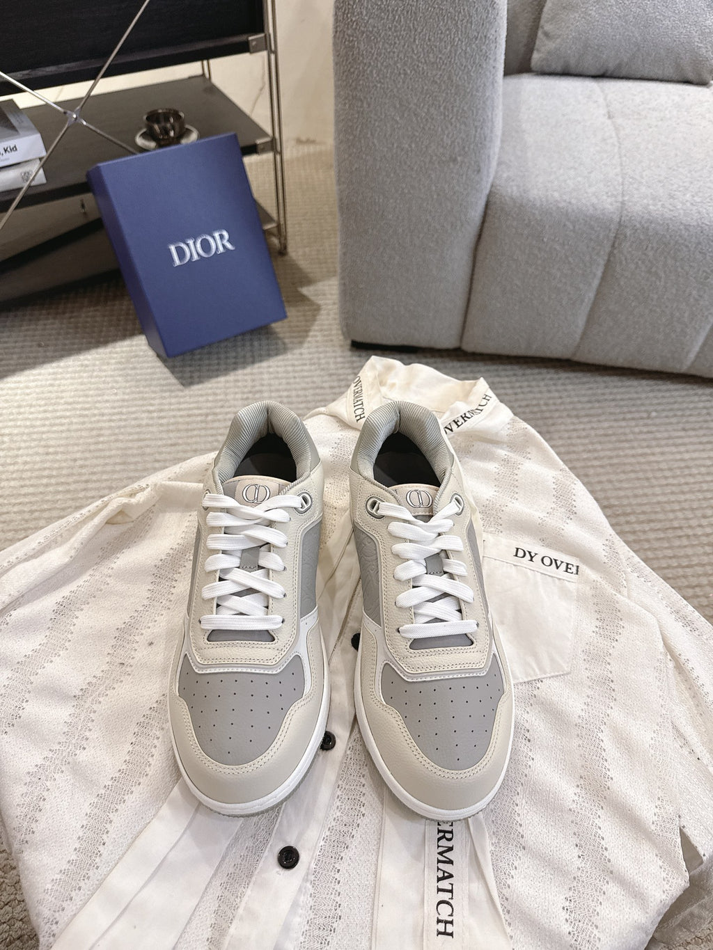 Pair of low-top sneakers in off-white with gray panels and white lace-up fronts