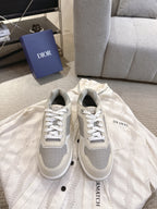 Pair of low-top sneakers in off-white with gray panels and white lace-up fronts