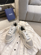 Pair of low-top sneakers in off-white with gray side panels and white lace-up uppers