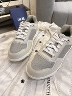 Pair of off-white low-top sneakers with gray perforated panels and white lace-ups
