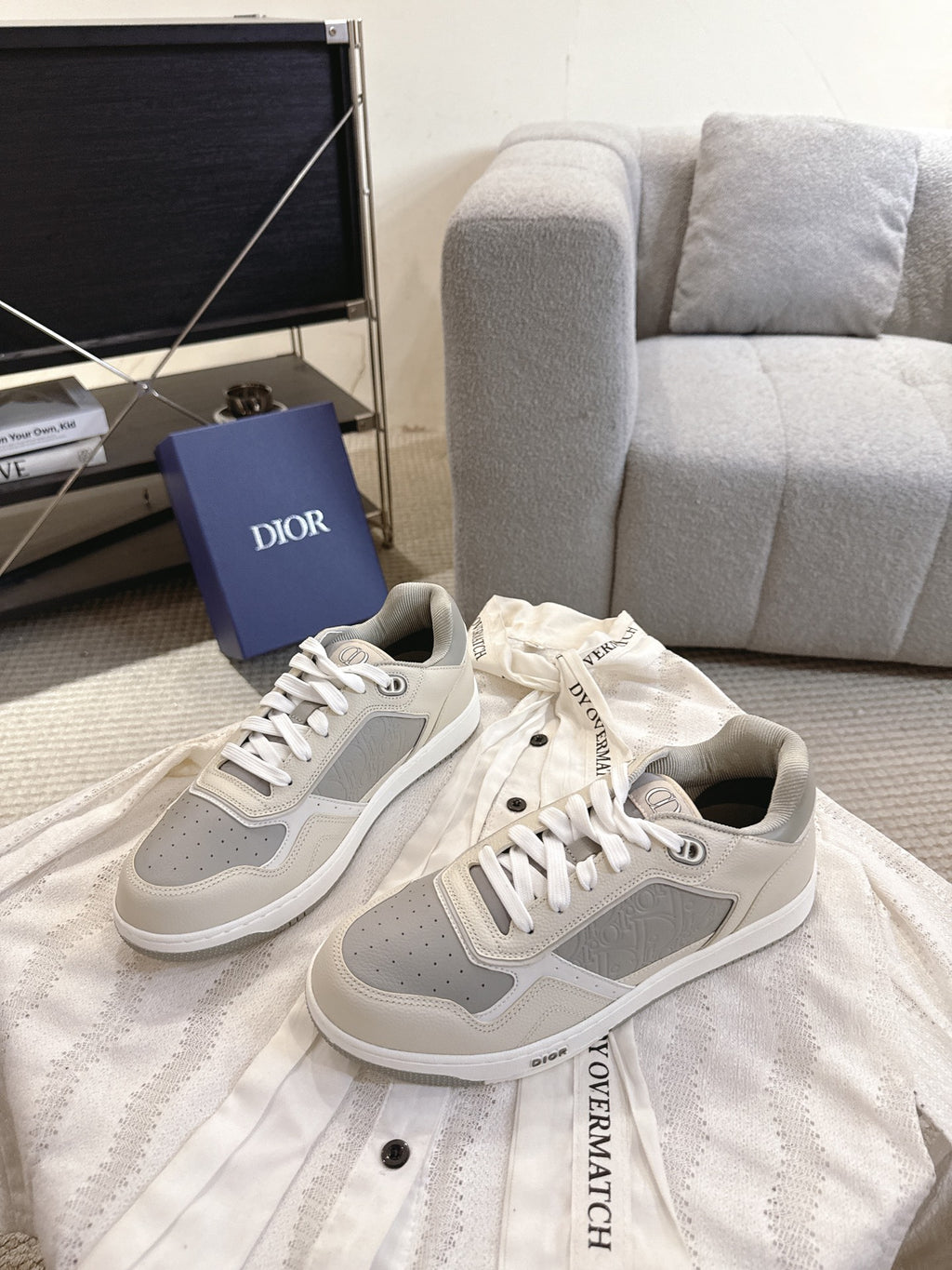 Pair of off-white low-top sneakers with gray side panels and white lace-up fronts