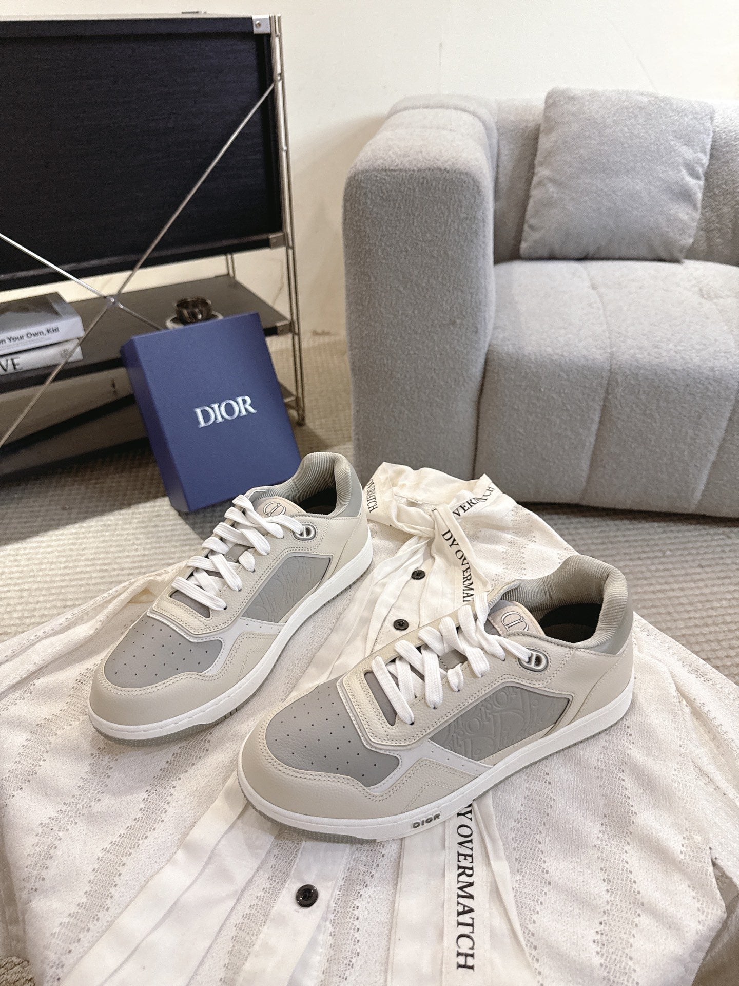 Pair of off-white low-top sneakers with gray side panels and white lace-up fronts