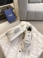 Pair of off-white low-top sneakers with gray side panels and white lace-up closure