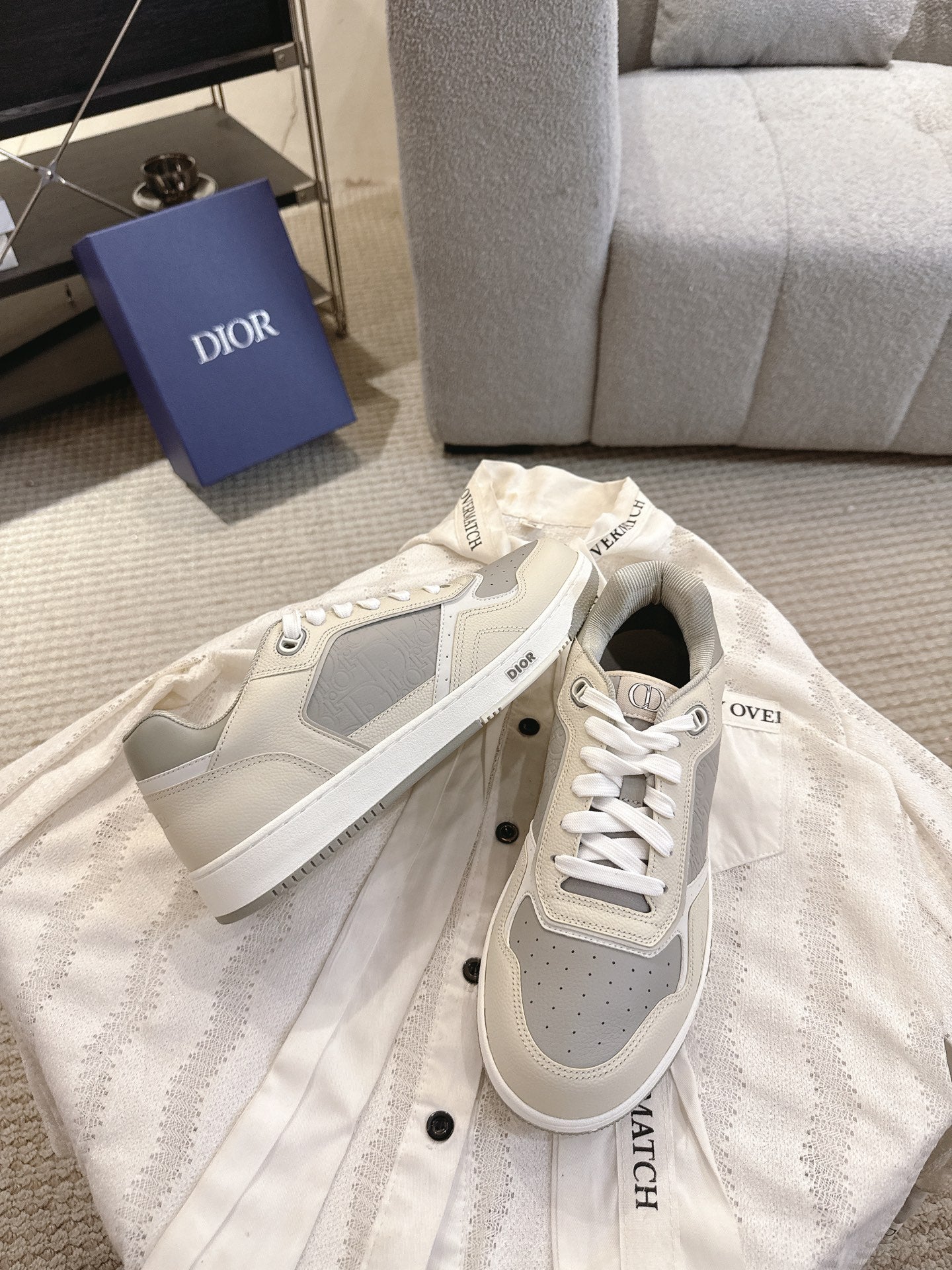Pair of off-white low-top sneakers with gray side panels and white lace-up closure