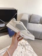Single off-white low-top sneaker with gray side panel and white lace-up upper
