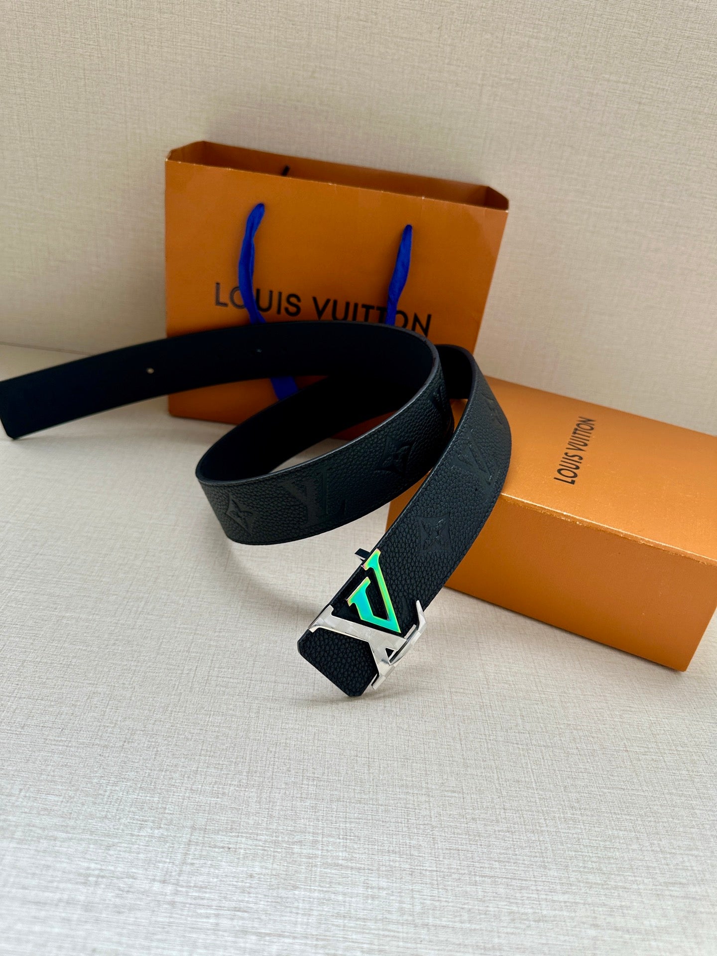 Louis Vuitton belt with dark blue strap and oversized silver LV buckle detail