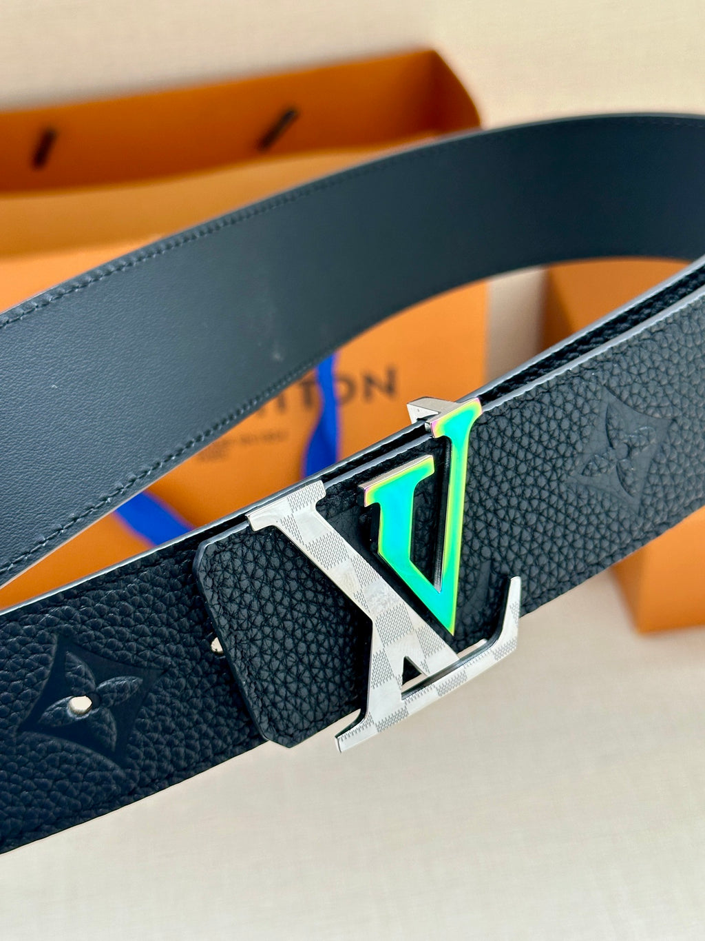 Louis Vuitton belt with close-up of dark blue textured strap and silver LV buckle