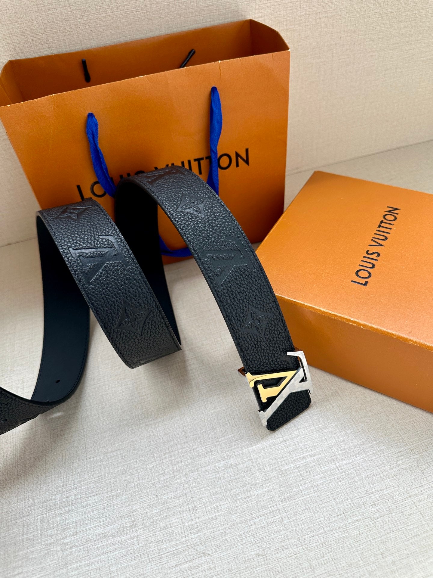 Louis Vuitton belt with dark blue textured leather loops and silver LV buckle