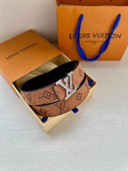 Louis Vuitton belt in open box with monogram print and silver-tone buckle