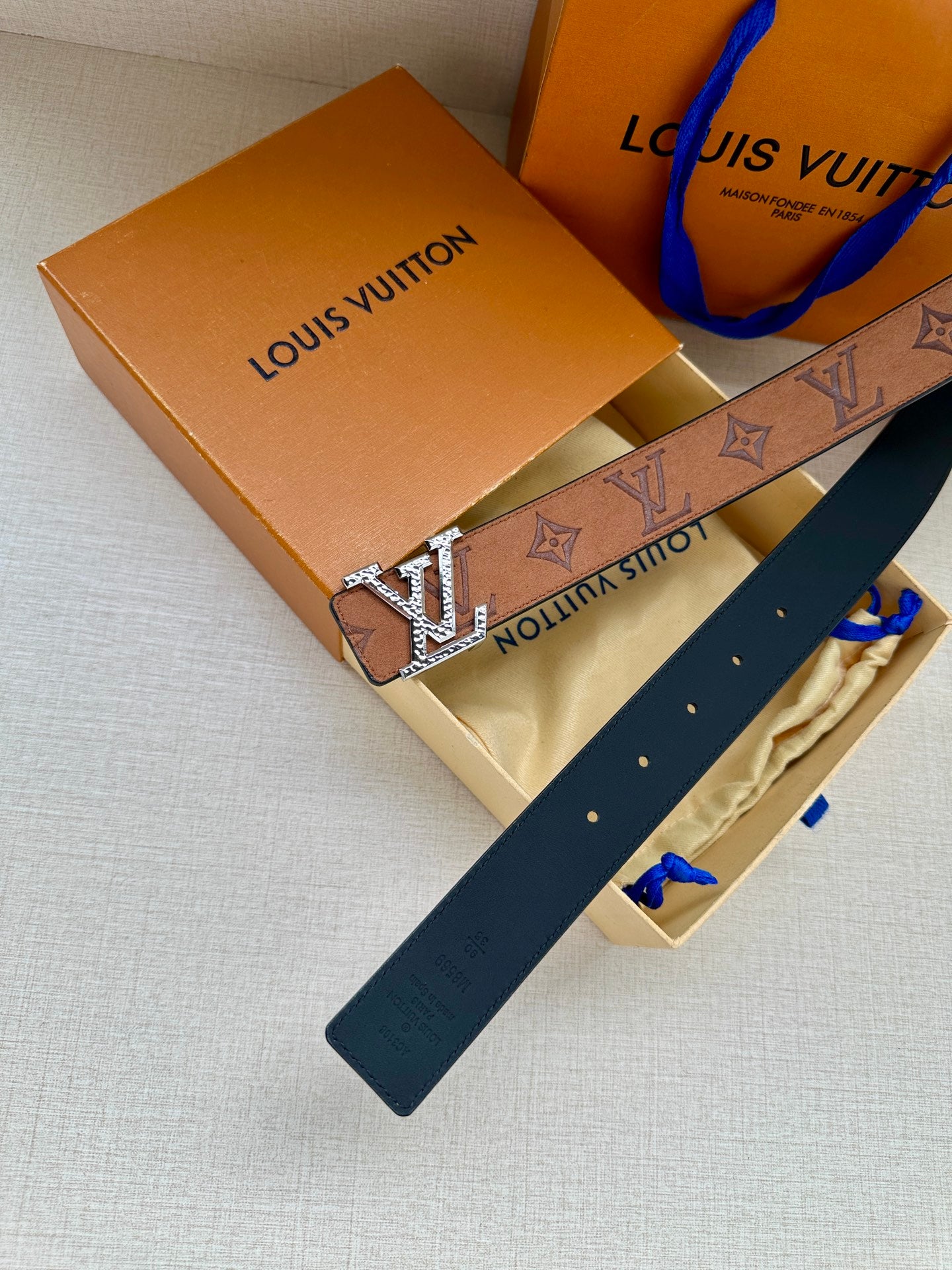 Louis Vuitton belt with monogram print and silver-tone buckle; navy belt strap end