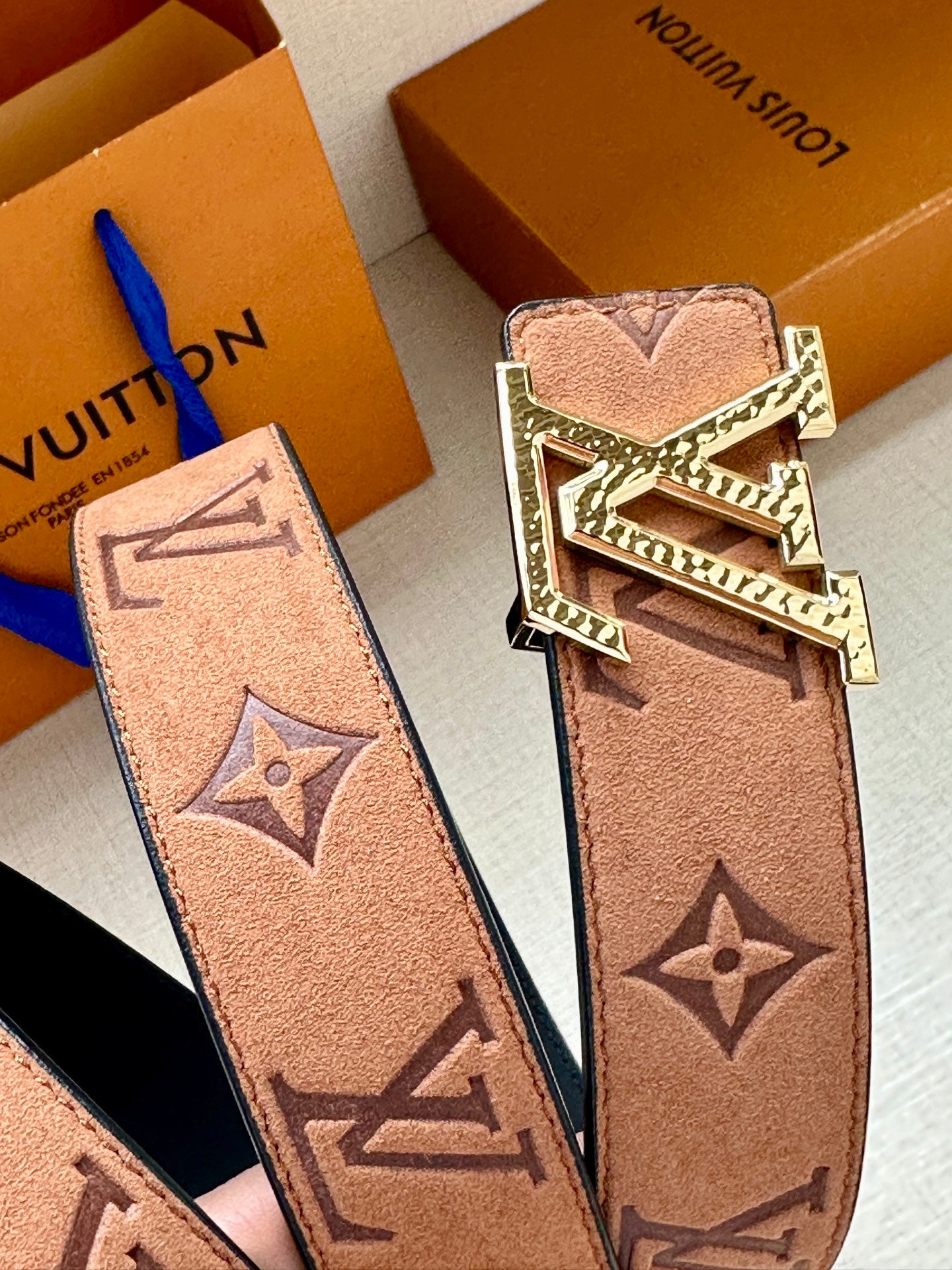 Louis Vuitton belt strap detail with monogram print and gold-tone LV buckle